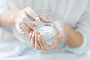 Beautiful woman hands applying moisturizer