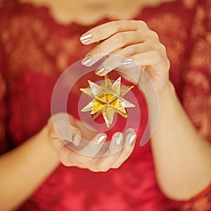 Beautiful woman hands with perfect nail polish holding christmas decorations