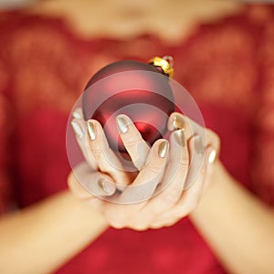 Beautiful woman hands with perfect nail polish holding christmas decorations