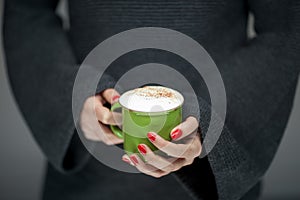 Beautiful woman hands with perfect nail polish holding coffee mug cup in her hand