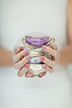 Beautiful woman hands with perfect pink nail polish holding little vintage tea cups