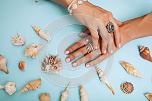 Beautiful woman hands with pink manicure holding plate with pearls and sea shells, luxury jewelry concept