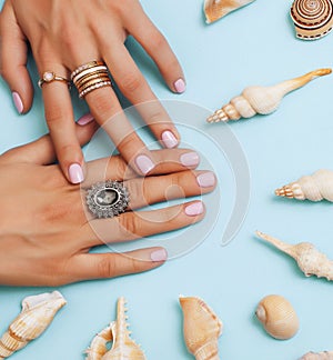 beautiful woman hands with pink manicure holding plate with pearls and sea shells, luxury jewelry concept