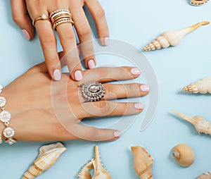 beautiful woman hands with pink manicure holding plate with pearls and sea shells, luxury jewelry concept