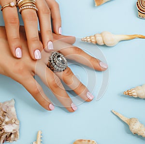 beautiful woman hands with pink manicure holding plate with pearls and sea shells, luxury jewelry concept