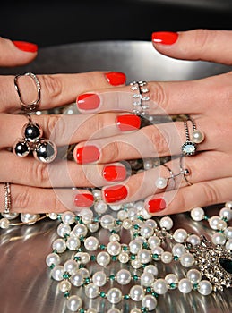 Beautiful woman hands with red pattern polish manicured nails food pearl