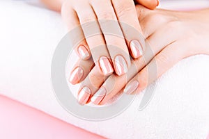 Beautiful Woman Hands on towel. Spa and Manicure concept. Female hands with pink manicure. Soft skin, skincare concept