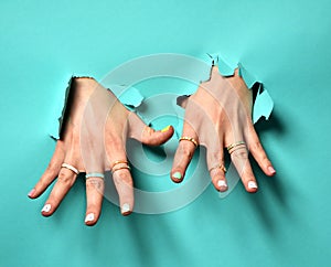 Beautiful woman hands with yellow pink white pattern nail polish and silver stacking rings and bracelets