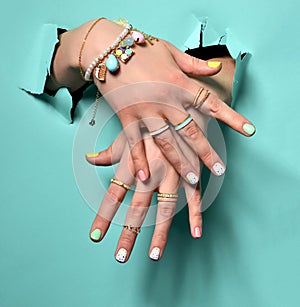 Beautiful woman hands with yellow pink white pattern nail polish