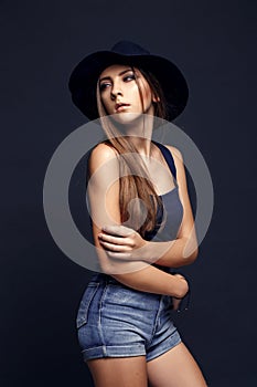 Beautiful woman in hat. Dark Background.