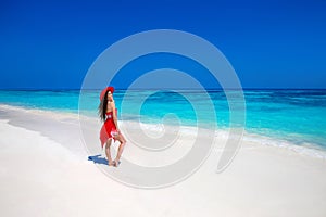 Beautiful woman in hat enjoying summer vacation on exotic beach