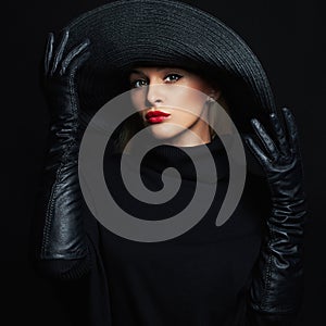 Beautiful woman in hat and leather gloves