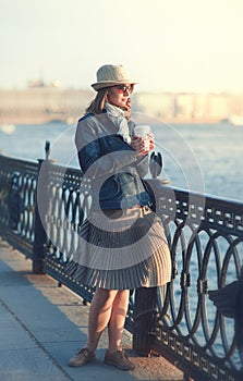 Beautiful woman in hat and scarf enjoy sunlight in the city