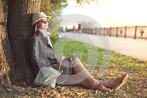 Beautiful woman in hat and scarf enjoy sunlight in the city