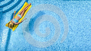 Beautiful woman in hat in swimming pool aerial drone view from above, young girl in bikini relaxes and swims