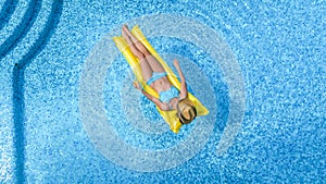 Beautiful woman in hat in swimming pool aerial drone view from above, young girl in bikini relaxes and swims