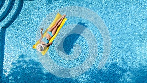 Beautiful woman in hat in swimming pool aerial drone view from above, young girl in bikini relaxes and swims