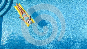 Beautiful woman in hat in swimming pool aerial drone view from above, young girl in bikini relaxes and swims