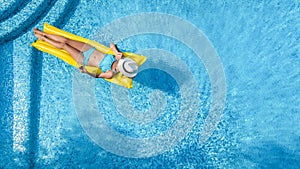 Beautiful woman in hat in swimming pool aerial drone view from above, young girl in bikini relaxes and swims