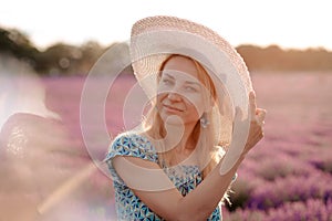 Beautiful woman in a hat walking in a lavender field