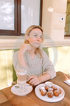 Beautiful woman having breakfast at a table in a cafe