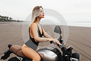 Beautiful woman having fun driving her motorcycle on the beach