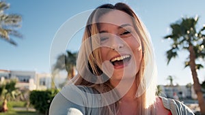 Beautiful woman having video chat using smartphone outdoors sharing travel adventure with friends. Girl filming selfie