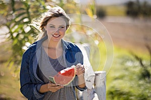 Beautiful woman having watermelon slice in park