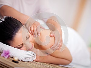 Beautiful woman having a wellness back massage at spa salon