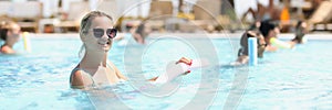 Beautiful woman with healthy body and vitality enjoys summer day in pool