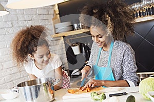 Beautiful woman and her daughter cooking in the kitchen