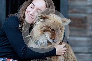 A beautiful woman and her dog nenets shepherd laika sitting.