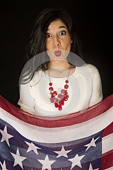 Beautiful woman with her lips puckered holding stars and stripes