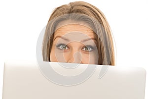 Beautiful woman hiding behind a laptop