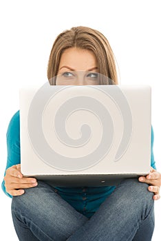 Beautiful woman hiding behind a laptop