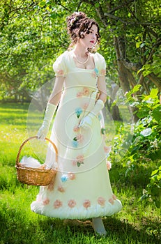 Beautiful woman in an historical bride dress with a wicker basket in her hands