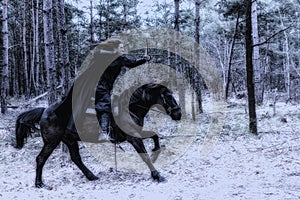 Beautiful woman in historical costume riding a horse and shooting a bow