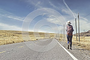 Beautiful woman hitchhiking on road in forest, hitchhiking with thumbs up in a countryside road, Travelling and hitchhiking concep