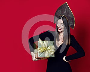 Beautiful woman hold gold Christmas presents gifts for new year celebration in kokoshnik hat