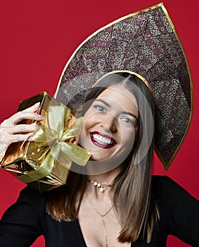 Beautiful woman hold gold Christmas presents gifts for new year celebration in kokoshnik hat