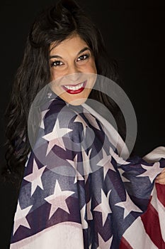 Beautiful woman holding an American flag over her shoulder