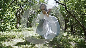 Beautiful woman holding apple in hand run through a garden, Snow White fairytale