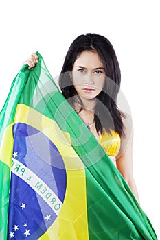 Beautiful woman holding a Brazil flag on studio