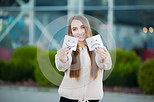 Beautiful woman holding cards with sad and funny smile