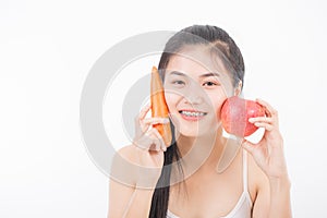 Beautiful woman holding carrot and apple