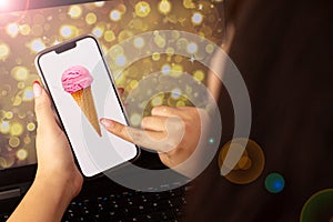 beautiful woman holding a cell phone that has an image of ice cream