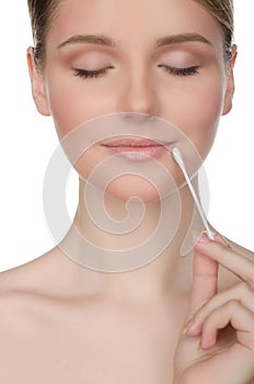 Beautiful woman holding cotton swabs at mouth