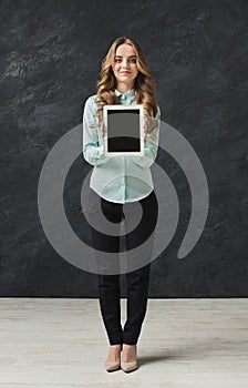 Beautiful woman holding digital tablet in studio