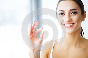 Beautiful Woman Holding Fish Oil Pill In Hand. Healthy Nutrition