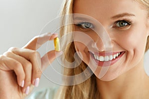 Beautiful Woman Holding Fish Oil Pill In Hand. Healthy Nutrition